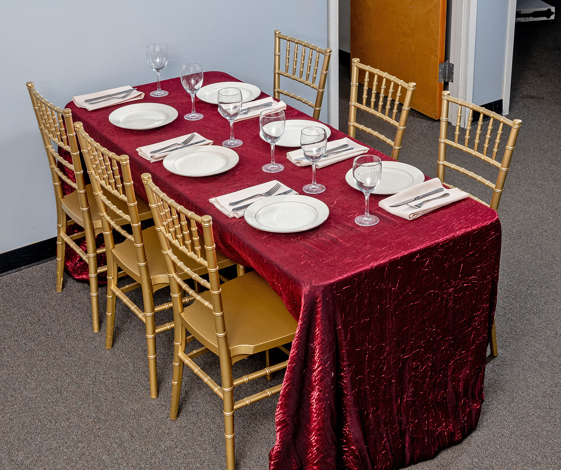 Gold Chiavari Chairs around a Rectangular Table with a Burgundy Majestic Tablecloth